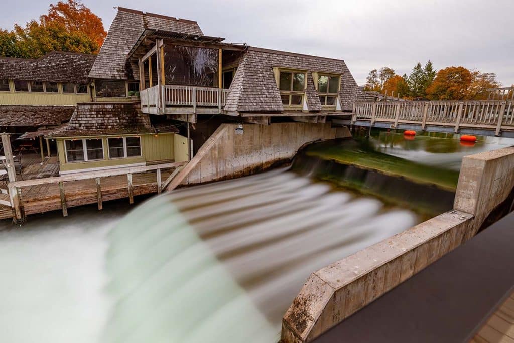 The Leland River dam at Fishtown, with weathered wooden fishing shanties along the bank.
